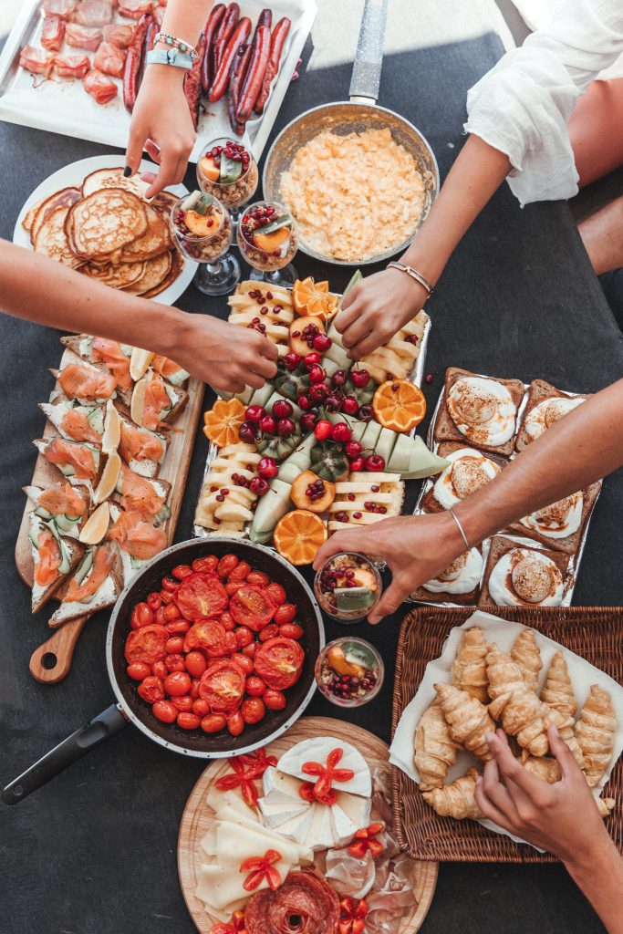 Overhead view of a breakfast spread with fruit, pastries, and appetisers