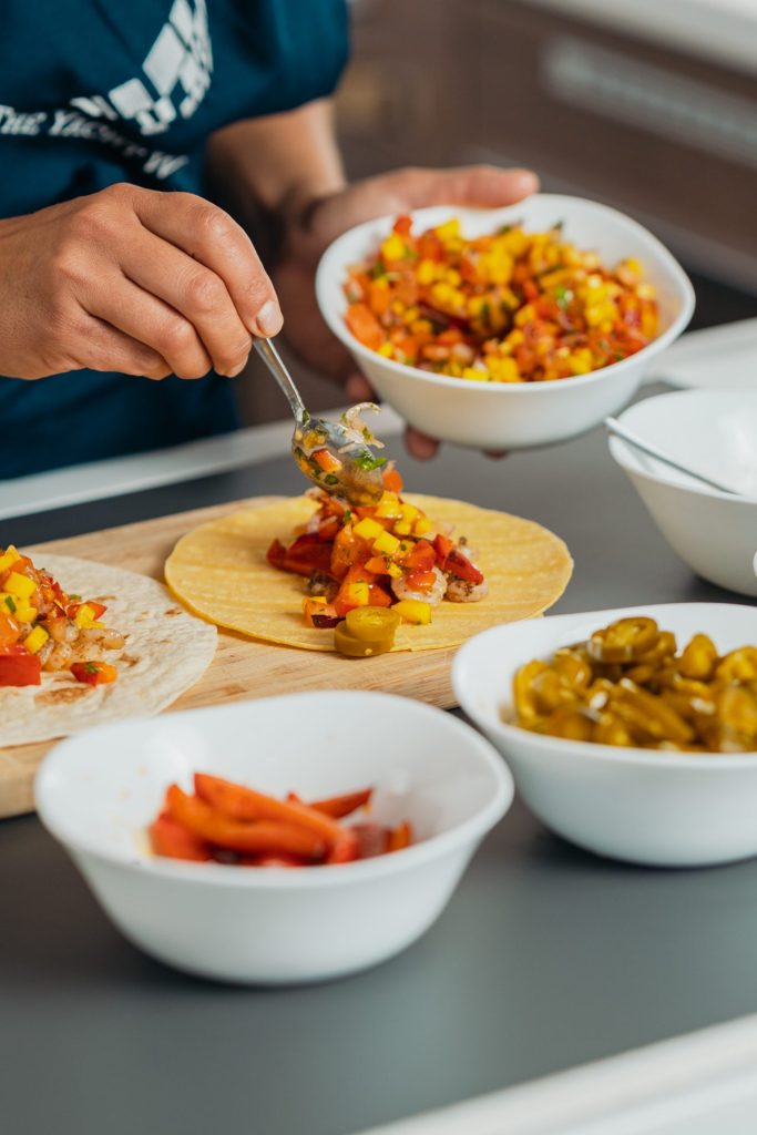 Preparing tacos with fresh vegetables and toppings